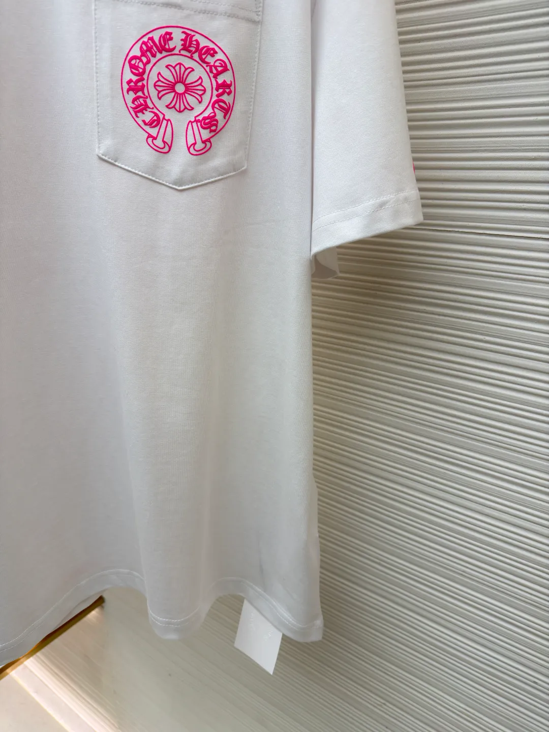 Chrome Hearts horseshoe pink T-shirt ●Item number: 1682507-X85 ●Fabric: cotton fabric ●Technology: hand-printed with ink ●Color: white ●Type: loose fit ●Weight: about 285 grams ●Size: S-M-L ●Description: This Chrome Hearts pocket printed short-sleeves are made of high-count double yarn cotton, with a weight of 320g. The fabric has been pre-washed to achieve a soft and skin-friendly touch. At the same time, it avoids shrinkage and fading problems from the root, and maintains a crisp shape after long-term wear. The body adopts seamless cylinder weaving technology, and there are no seams on the sides, so there is no sense of restraint when worn. The shoulders are classic dropped shoulders, and the loose body shape is suitable for all kinds of body shapes. The rose-red totem print on the left breast pocket is made of imported environmentally friendly slurry and produced through a high-precision screen printing process. The printing has clear layers and saturated colors, and it is not easy to crack or fall off after repeated washing. The neckline adopts a double-needle reinforced hemming design and is paired with a customized threaded collar, which is durable and not easily deformed. The overall wiring follows luxury craftsmanship standards, and the stitching is even and fine. Every detail demonstrates ingenuity. Customized hardware and accessories are complete with three logos, restoring the classic texture of the brand. The overall wiring is straight and delicate, the fabric is comfortable and soft, and the color is consistent without color difference. It can be matched with the same style to create a fashionable look and control various occasions. Customized accessories, complete with three standards, same style for men and women!